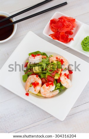 Shrimp and avocado salad over wooden background