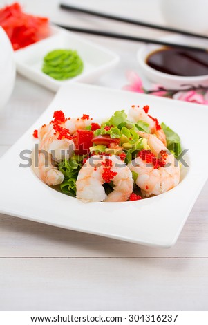Shrimp and avocado salad over wooden background