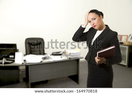 Stressed young business woman,inside her office.