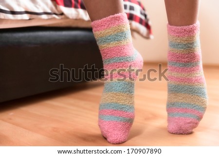 Close up of a person walking on its tip toes, inside bedroom.
