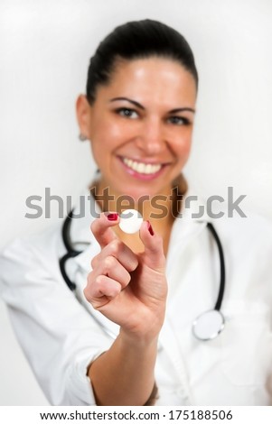 Portrait of a female doctor, holding medicament and smiling, isolated on white background.