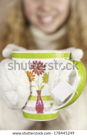 Smiling woman holding mug of tea.