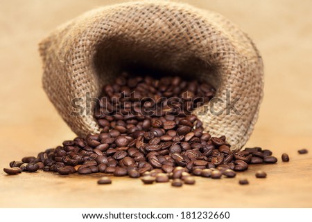Sack of fresh roasted coffee beans over light background.