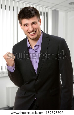 Happy young business man inside his office.