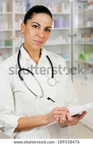 Close up of a beautiful woman doctor signing medicine prescription.