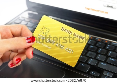 Businesswoman holding credit card while e-banking / shopping online.
