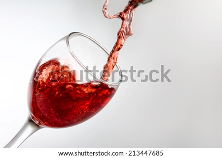 Red wine poured inside wine glass.