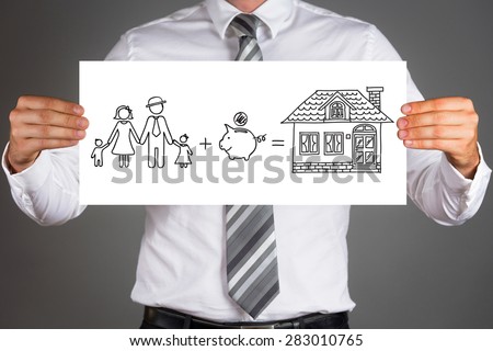 Money saving concept.Business man holding a drawing of a family,saving money to buy a house.