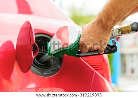 Close up of a worker hand, loading gas into car. Gas station.