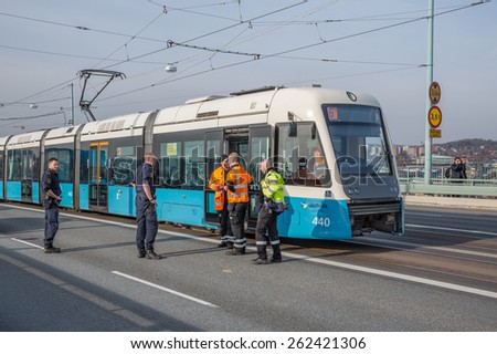 Goteborg, Sweden - March 19, 2015: Police and service technician working to take care of a non working tram that is blocking the traffic with major implications in a city with heavy traffic.