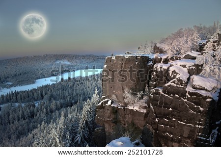 Full moon up the mountain forest in morning snow.