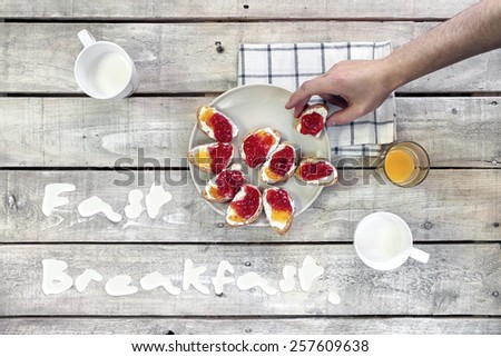 Fast breakfast quotes, top view of white wood table with breakfast sandwiches in hand, juice and milk.