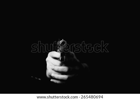 female hand holding gun with a black background