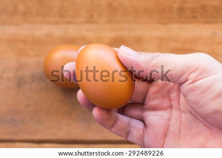 Fresh eggs on the wooden table and have people come to collect the eggs to cook.