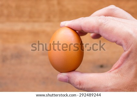 Fresh eggs on the wooden table and have people come to collect the eggs to cook.