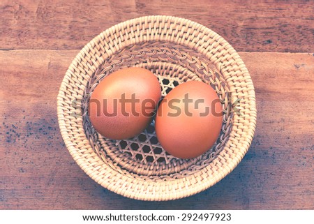 Fresh eggs on the wooden table and have people come to collect the eggs to cook and color reproduction vintage portrait or older.