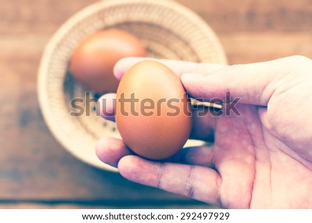 Fresh eggs on the wooden table and have people come to collect the eggs to cook and color reproduction vintage portrait or older.