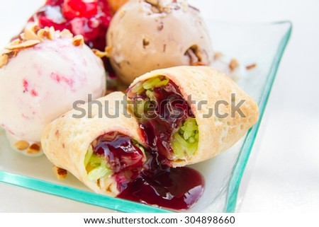 Ice cream is a mixture of sweet fermented rice with pandan leaves topped with blue berries wrapped in a soft dough and cherry red.