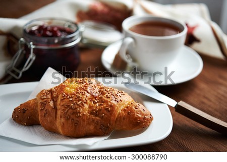 croissant with sesame and cup of coffee