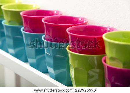 Line of colorful plastic cups on a shelf