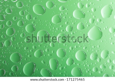 Clear green water drops over green background