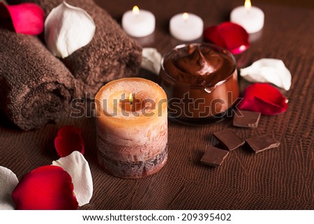 SPA concept: chocolate mudpack, rose petals, candle and towels