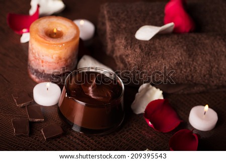 SPA concept: chocolate mudpack, rose petals, candle and towels
