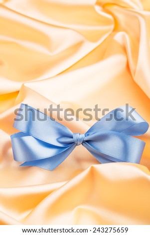 Blue ribbon satin bow on the nice yellow silk