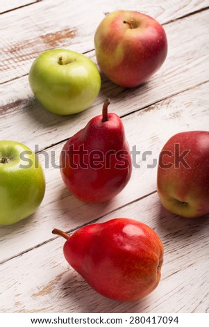 Apples and pears on the white wooden background
