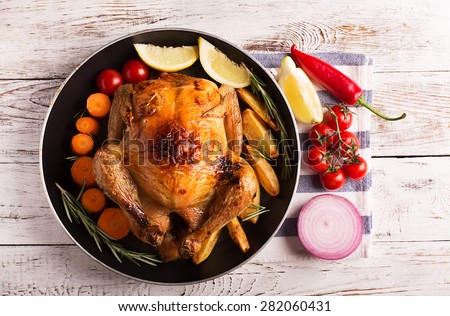 Roasted chicken and vegetables on the wooden table