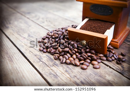 Coffee mill with coffee beans and ground coffee.