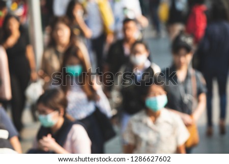 Blurred people wearing mask against air smog pollution with PM 2.5 in Bangkok city, Thailand.
