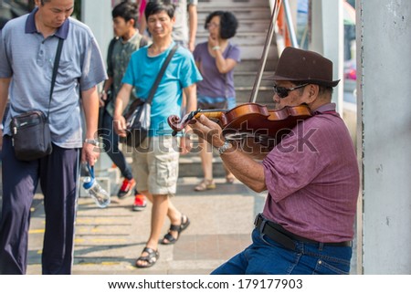 BANGKOK - FEB 22:Man plays violin in Jatujak market,the famous weekend market on Feb 22, 2014 in Bangkok,Thailand is one of the destination of foreigners Only open Saturdays and Sundays
