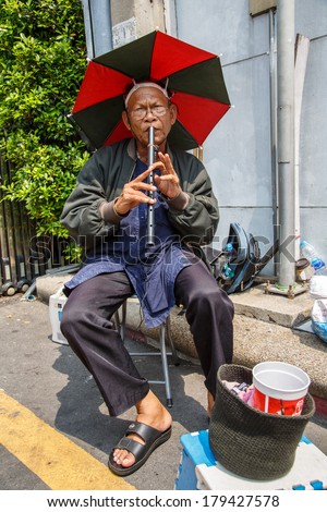 BANGKOK, THAILAND - FEBRUARY 28 :Unidentified street musician plays  at walking street market in Bangkok,Thailand on 28 February 2014
