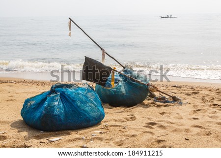 Trawler fishing nets and equipment set out on the beach thailand
