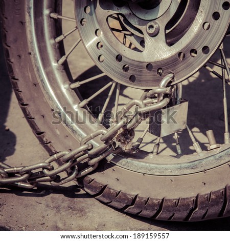 Security lock blocking the motorcycle wheel, process color