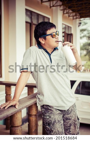 asia young Man drinking ice coffee water from plastic cup at outdoor, process color