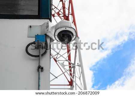 Remote controlled security camera against blue sky