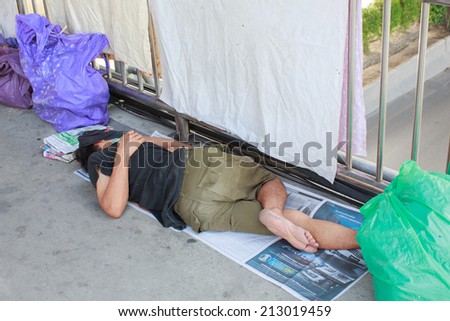 BANGKOK - Aug 25: An unidentified man sleeps on the street in city centre on Aug 25, 2014 in Bangkok, Thailand. The government estimates 4,000 homeless in Bangkok while NGOs put the figure far higher