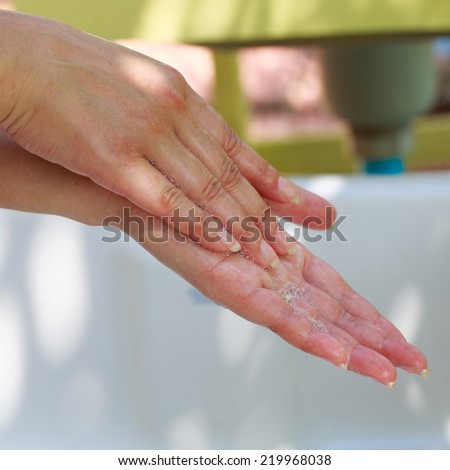 Close-up of human hands being washed with soap
