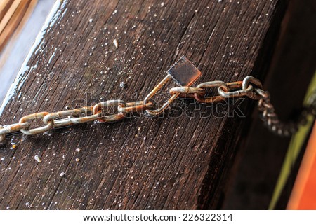 old wooden surface with chains and lock, concept of security