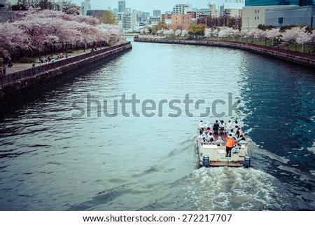 The Osaka, Japan - 12 April 2015: Okawa River cruise Sakuragi and views of Osaka from the bridge Tenmabashi during Sakura bloom.