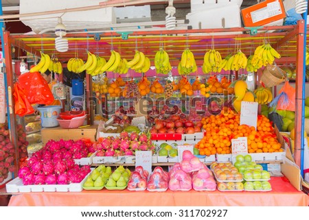 SINGAPORE - AUGUST 1: A seller and customer trades at a fresh fruits stall on August 1, 2015 in Bugis Market, Singapore. The traditional Asian wet market still exist in this modern city.