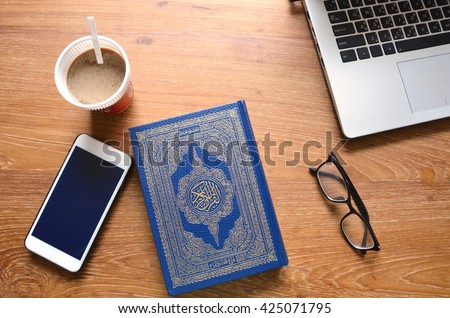 Reading The Holy Quran(Islamic Book) on Wooden table.