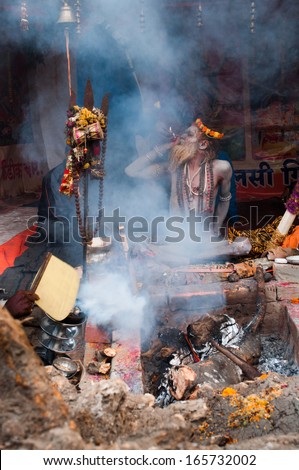 BABUGHAT, KOLKATA, WEST BENGAL / INDIA - 9TH JANUARY 2013 : A Sadhu (Hindu Saint) smokes on 9th January, 2013 in Babughat, Kolkata. They are on their way to Gangasagar (Sagar) - Holy place for Hindus.