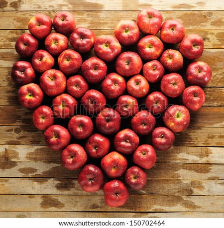 Composition heart of red apples lying on wooden boards/Heart of apples