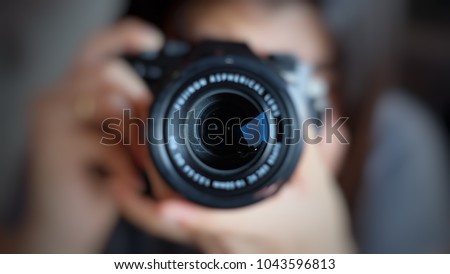 Soft focus of women photographer hold camera and taking a photo.