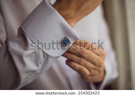 The man in the white shirt in the window dress cufflinks.