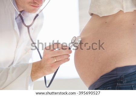Healthcare, medical: Doctor examining a pregnant woman.