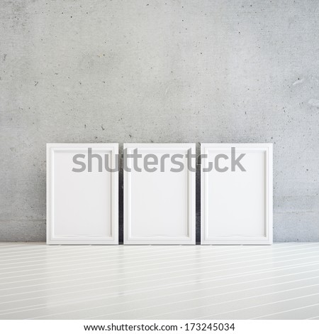 3 white frame on a white floor near concrete wall